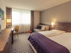 a hotel room with two beds and a desk at Mercure Hotel Frankfurt Eschborn Ost in Eschborn