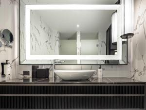a bathroom with a sink and a large mirror at Sofitel Adelaide in Adelaide +114 photos