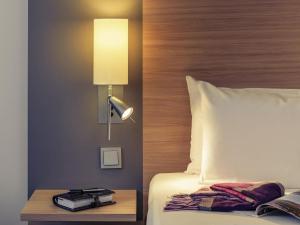 una habitación de hotel con una cama con una lámpara en una mesa en Fürther Hotel Mercure Nürnberg West, en Fürth