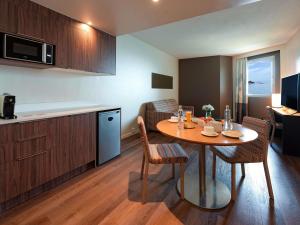 Una cocina y un comedor con mesa y sillas. en Novotel Dakar, en Dakar