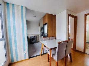 a kitchen with a table and chairs in a room at Ap 2 Quartos 5km da BR, Palhoça in Palhoça