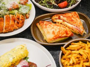 a table topped with plates of food and french fries at Pullman Paris Montparnasse in Paris