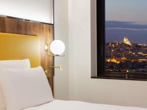 a bedroom with a window with a view of a city at Pullman Paris Montparnasse in Paris