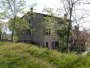 uma antiga casa de pedra numa colina com árvores em I Vigneti Bed & Breakfast em Salionze