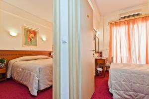 ピレウスにあるトリトン ホテル ピレウスのベッドが2つと窓があるホテルの部屋 +24枚の写真