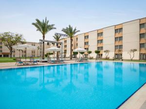 a large swimming pool in front of a hotel at Novotel Cairo Airport in Cairo
