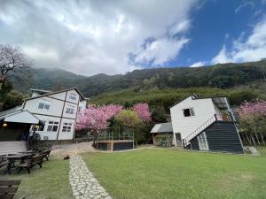 two houses and a picnic table in a yard at 迦南山莊 in Wufeng