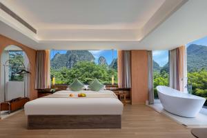 a bedroom with a large bed and a bath tub at Riverside Bamboo Frest Hotel in Xingping +46 photos
