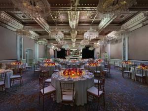 a banquet hall with tables and chairs and chandeliers at Raffles Singapore in Singapore +187 photos