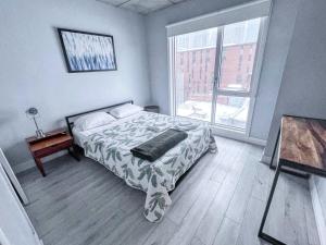 Un dormitorio con una cama y una ventana grande. en Downtown Elite Residences, en Montreal
