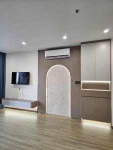 an empty room with a wall with a tv and a wall at Luxhomes TC1 Canopy Smart City in Phú Thú +22 photos