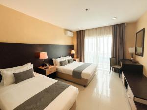 a hotel room with two beds and a window at The Lake Hotel Tagaytay in Tagaytay +12 photos