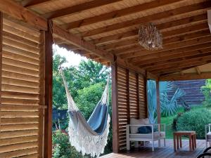 a hammock hanging from a pergola on a patio at Gîte soufrière in Saint-Claude