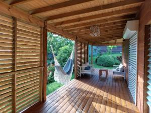 a wooden deck with a hammock on it at Gîte soufrière in Saint-Claude