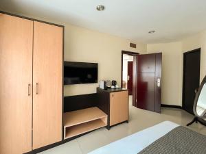 a bedroom with a large cabinet and a television at The Lake Hotel Tagaytay in Tagaytay