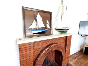 a brick fireplace with two sailboats on top of it at Charmante maison entre Port Tudy et le Bourg à Groix - FR-1-813-34 in Groix