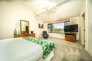 a bedroom with a bed and a flat screen tv at Kaanapali Royal B303 · KRL B303 Relaxing 2BD on Golf Course w Po in Lahaina