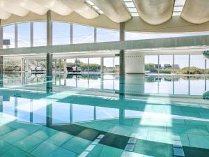a large swimming pool with blue water and windows at Sofitel Quiberon Thalassa sea & spa in Quiberon
