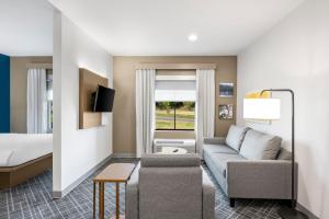 a hotel room with a couch and a bed at Comfort Inn & Suites Fort Smith I-540 in Fort Smith