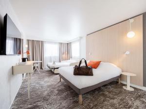 una habitación de hotel con 2 camas y un bolso en Novotel Paris 13 Porte d'Italie, en Le Kremlin-Bicêtre