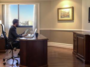a man sitting at a desk with a laptop at Grand Mercure Sao Paulo Ibirapuera in Sao Paulo +245 photos