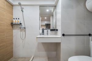 a bathroom with a shower and a sink and a toilet at 来咖民宿酒店海口保利中央海岸店 in Pin-lien +55 photos