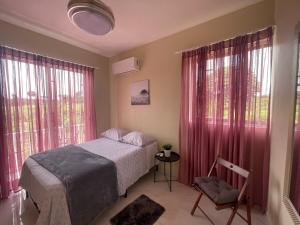 a bedroom with a bed with pink curtains and a chair at Jeda Village in Higuey +27 photos