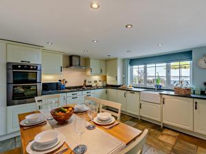 a kitchen with a wooden table with chairs and a dining room at 2 Bed in Ravenglass 95884 in Ravenglass