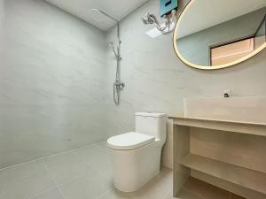 a bathroom with a toilet and a sink and a mirror at White Sand in Himandhoo 
