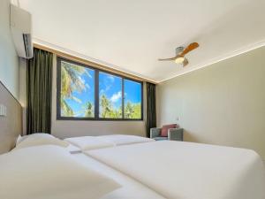 a hotel room with two beds and a window at White Sand in Himandhoo 