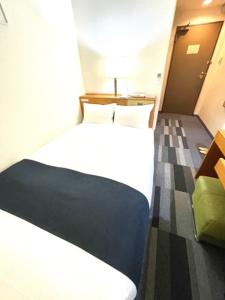 青森市にある青森グリーンパークホテルの白いベッドと机のあるホテルの部屋
