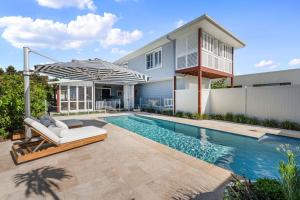 a swimming pool in front of a house at Lambent - Casuarina House in Casuarina