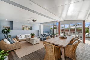 a living room with a wooden table and chairs at Lambent - Casuarina House in Casuarina