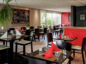 a restaurant with tables and chairs with red napkins at ibis Vannes in Vannes
