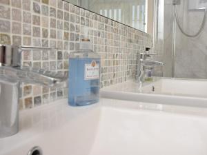 - Botella de agua encima del lavabo del baño en 3 Bed in Fakenham 56661, en Whissonsett 15 fotos más