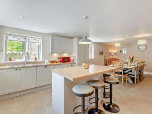 a kitchen with a counter and a table with stools at 4 Bed in Kirkby Lonsdale 54457 in Whittington