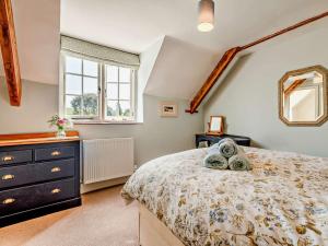 コーフ・キャッスルにある4 Bed in Isle of Purbeck IC101のベッドとドレッサーと窓のある寝室