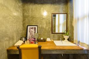 een badkamer met een wastafel en een spiegel bij The Wishes Hotel at Chiangmai in Chiang Mai