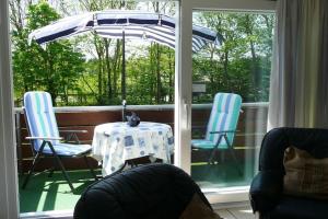 オルディングにあるFerienwohnung in St Peter-Ordingのポーチ(テーブル、椅子、パラソル付)