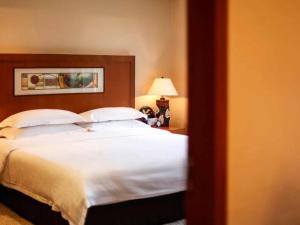 a bedroom with a large bed with white sheets at Pullman Zhangjiajie Hotel - Instagrammable in Zhangjiajie