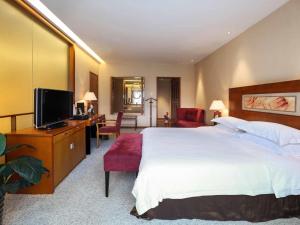 a hotel room with a large bed and a television at Pullman Zhangjiajie Hotel - Instagrammable in Zhangjiajie