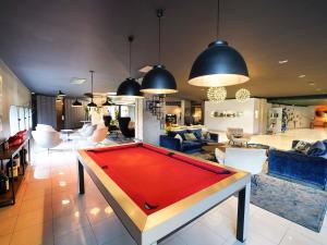 a living room with a pool table in the middle at Pullman Bordeaux Lac in Bordeaux +188 photos