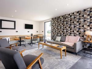a living room with a couch and a table at ibis Dijon Sud in Perrigny-lès-Dijon