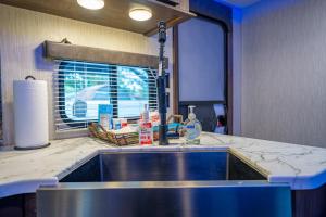 a kitchen counter with a sink and a window at The Backyard Glampground - Camper Fire Pit & Games in Tampa