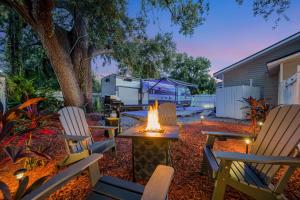 a backyard with chairs and a table with a fire pit at The Backyard Glampground - Camper Fire Pit & Games in Tampa