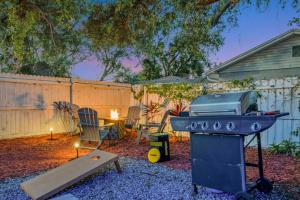 a grill in a backyard with a table and chairs at The Backyard Glampground - Camper Fire Pit & Games in Tampa