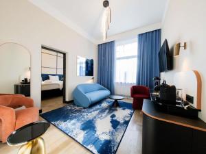 a living room with a blue chair and a blue rug at TRIBE Riga City Centre in Rīga +156 photos
