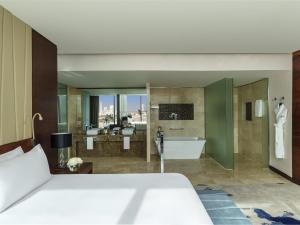 a bedroom with a large bed and a bathroom at Fairmont Bab Al Bahr in Abu Dhabi