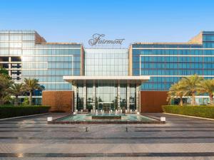 a large glass building with a fountain in front of it at Fairmont Bab Al Bahr in Abu Dhabi