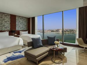 a hotel room with a bed and a couch at Fairmont Bab Al Bahr in Abu Dhabi